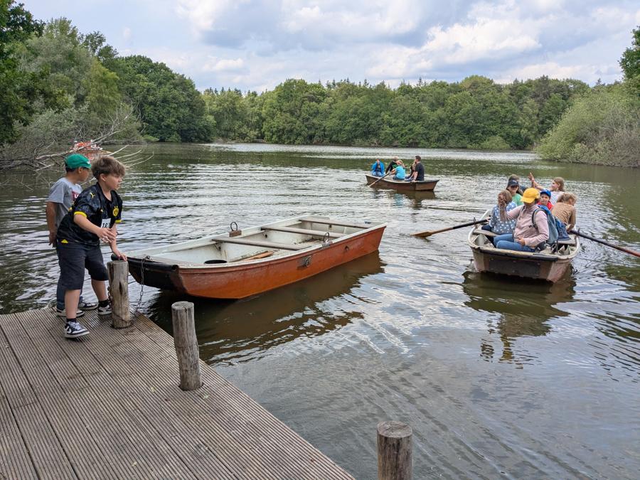 Klassenfahrt: Kinder mit Ruderbooten am See