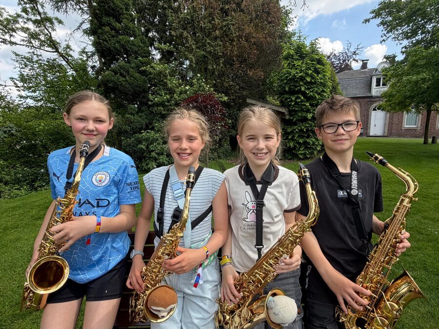 Vier Kinder der Orchesterklasse mit ihren Saxophonen im Park